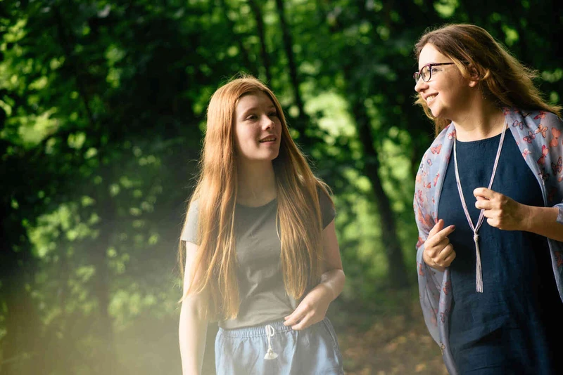 ein m&auml;dchen und eine frau gehen drau&szlig;en spazieren